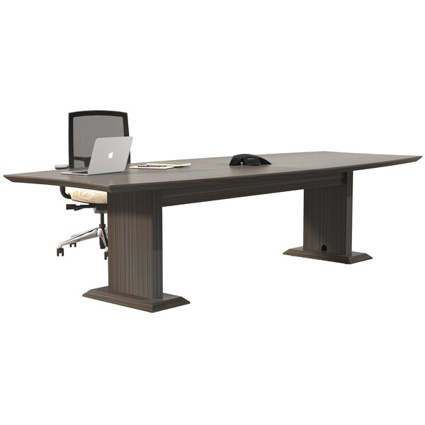 A Safco Sterling driftwood rectangular conference table with a laptop on it.