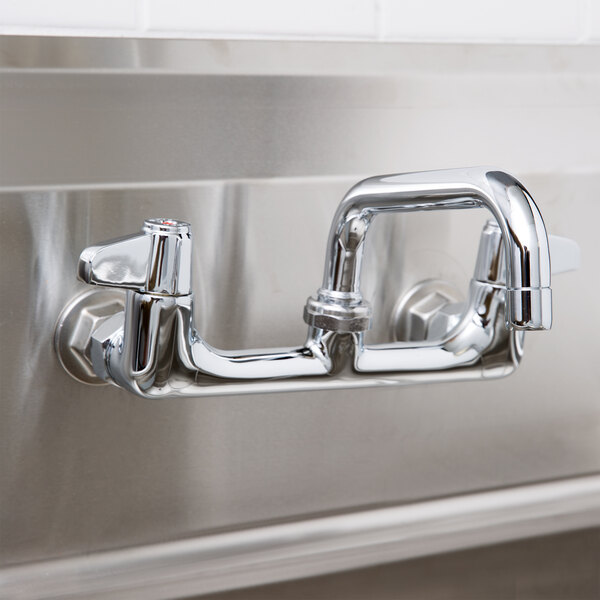 A chrome Equip by T&S wall mounted faucet with lever handles and a 6 1/8" swing spout.