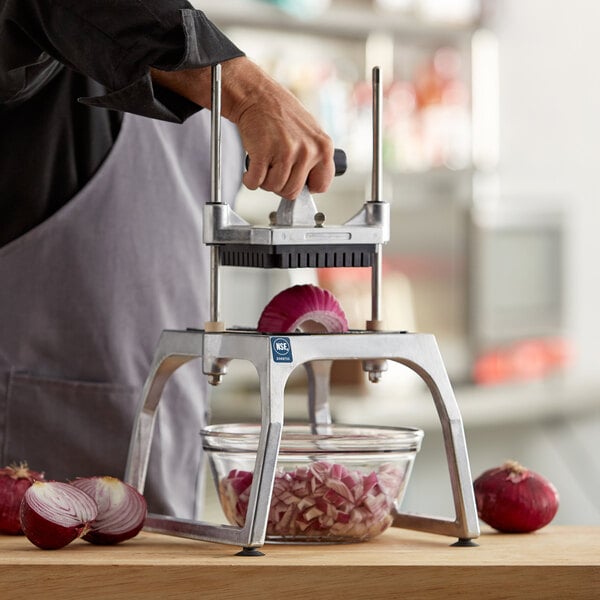 A person using a Vollrath vegetable dicer to slice a red onion.