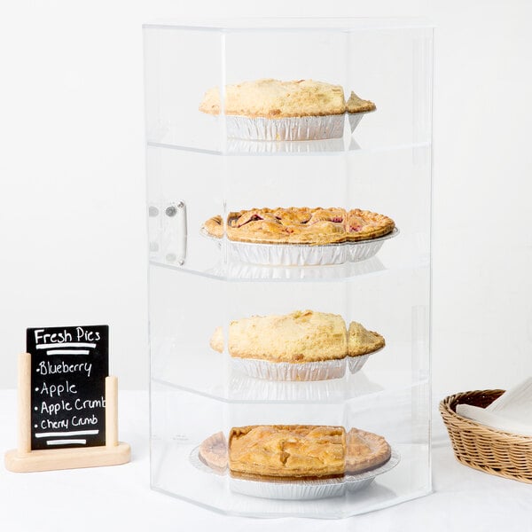 A Cal-Mil clear acrylic display case with four tiers holding pies.