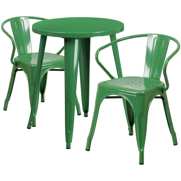 A green metal table with two green metal arm chairs.