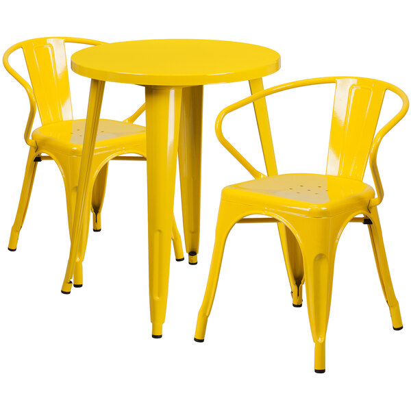 A yellow metal Flash Furniture table with two yellow arm chairs.