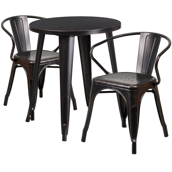 A black metal table with two black metal chairs on a table in a restaurant dining area.