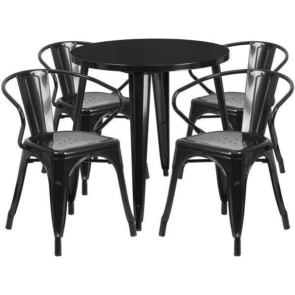 A black metal round table with four black metal chairs.