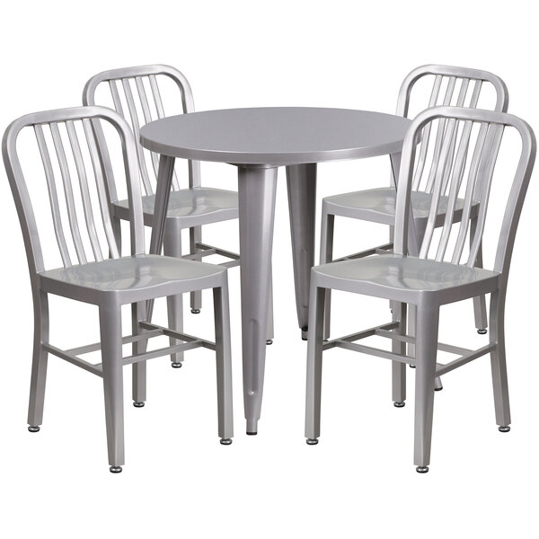 A Flash Furniture silver metal table with four vertical slat back chairs around it.
