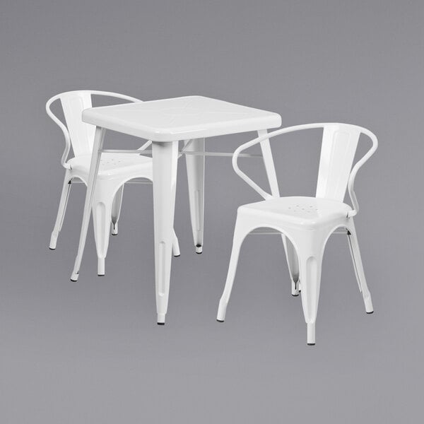 A white metal table with two white chairs.