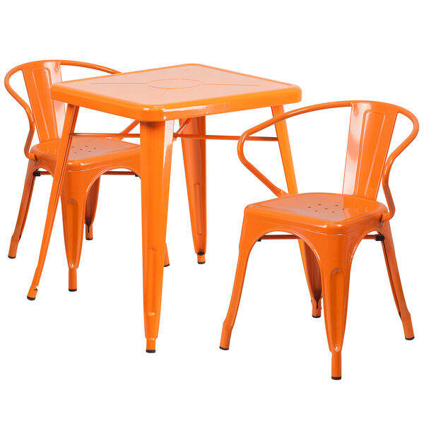 An orange metal square table with two chairs with arms.