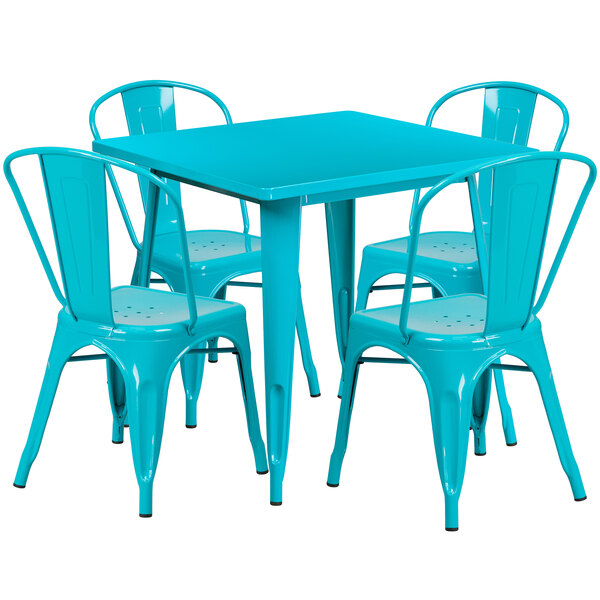 A teal metal table with four chairs, one blue and three teal.