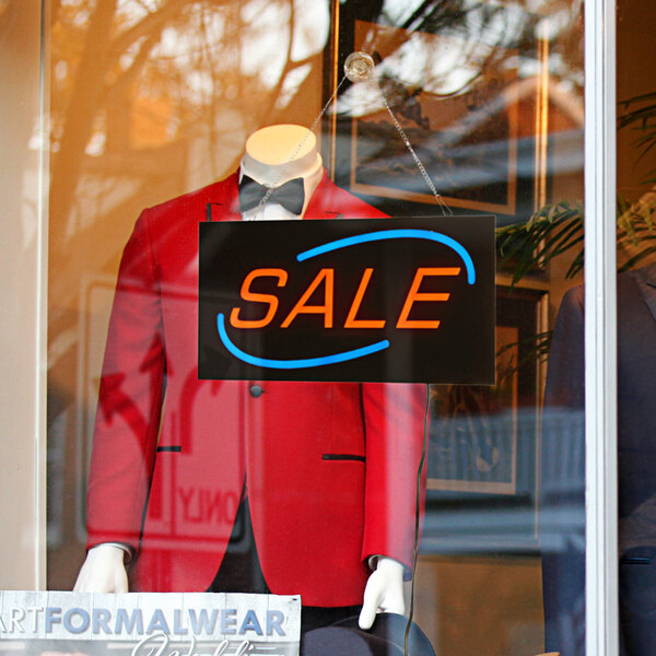 A mannequin wearing a suit and bow tie with a Choice LED rectangular sale sign in a window.