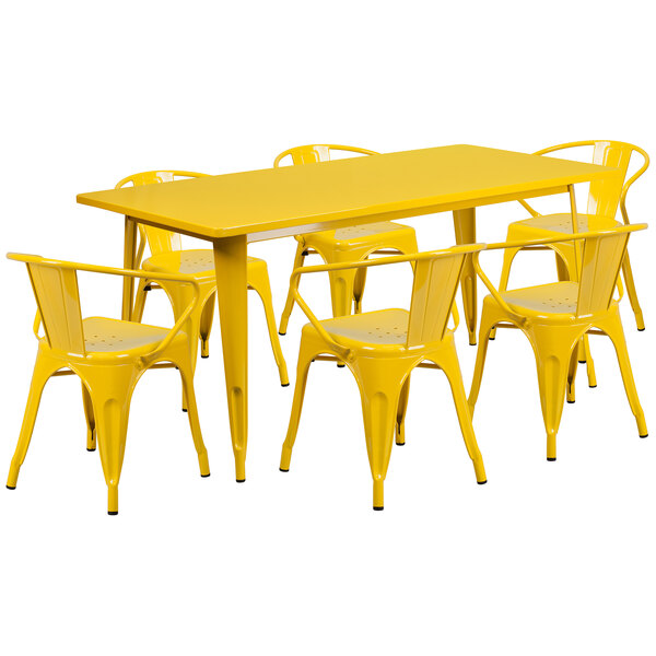 A yellow rectangular dining table with six yellow metal arm chairs.