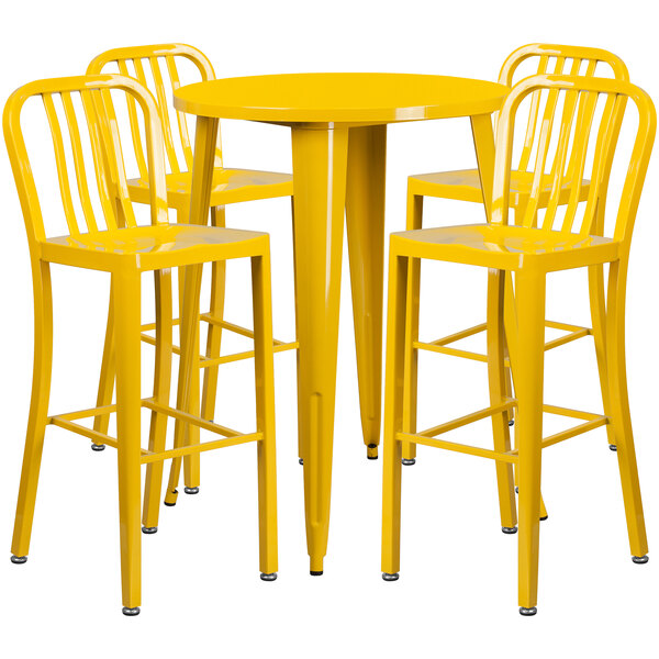 A yellow metal bar height table with four yellow chairs.
