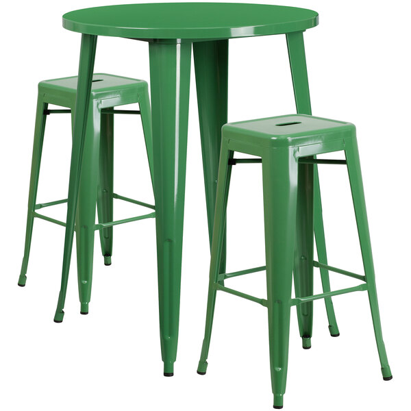 A green metal bar table with a green metal table and two square seat backless stools.