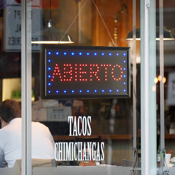 A rectangular white LED sign that says "Abierto" in lights.