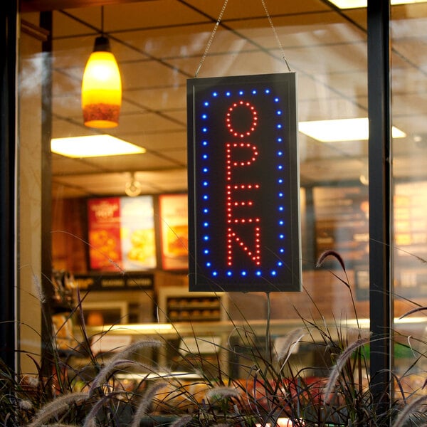A Choice rectangular LED open sign hanging in a window.