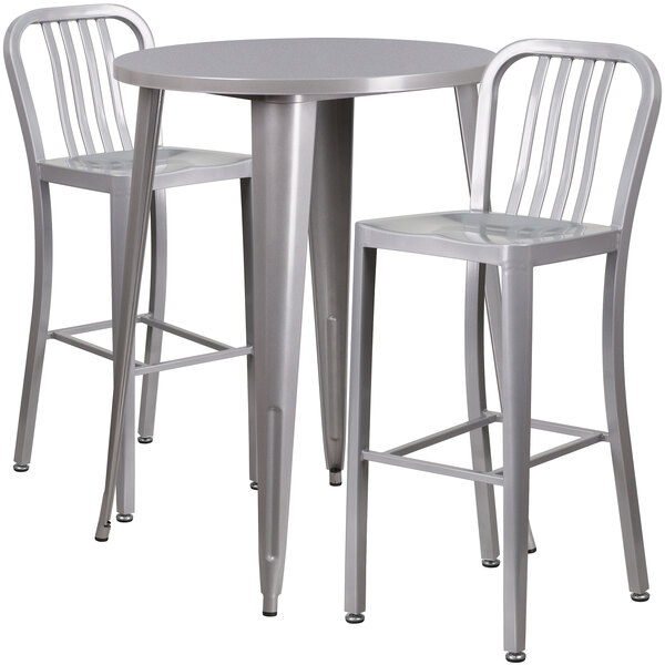 A white table with silver legs and two silver chairs with vertical slat backs.