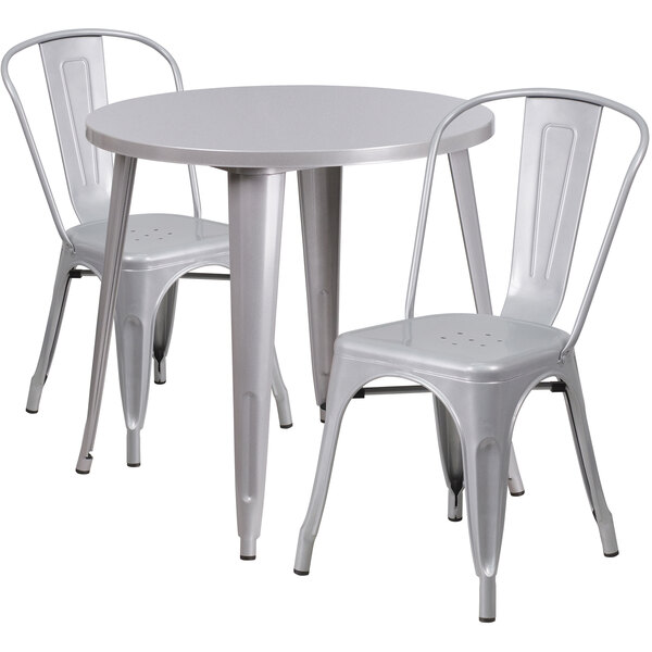 A silver metal table with a silver rim and two silver metal chairs.