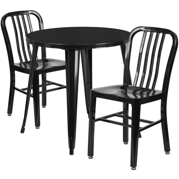 A black table with two black metal chairs.