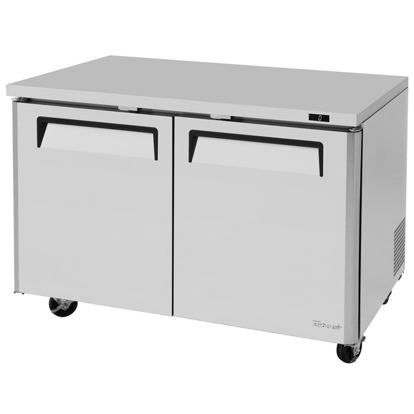 A white Turbo Air undercounter freezer with black handles.