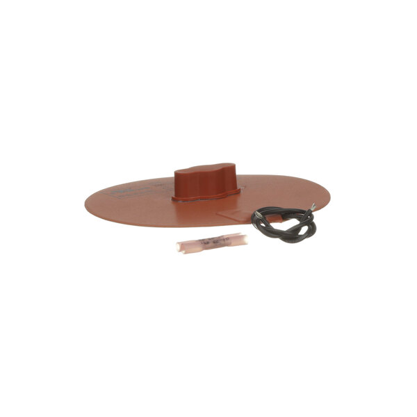 A brown circular plastic lid with a metal wire on a table.