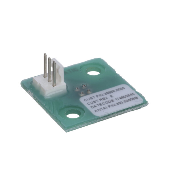 A green circuit board assembly with a small green electronic component and white plastic plug.