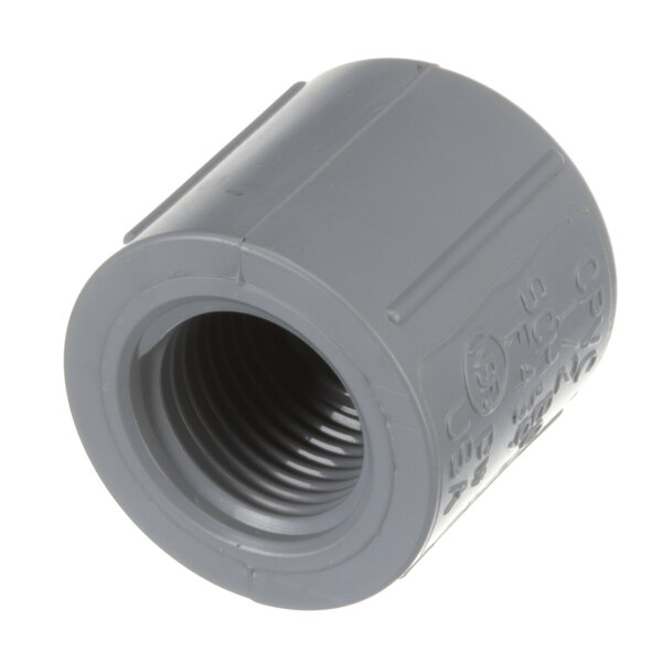 A close-up of a grey plastic pipe fitting with writing on it.