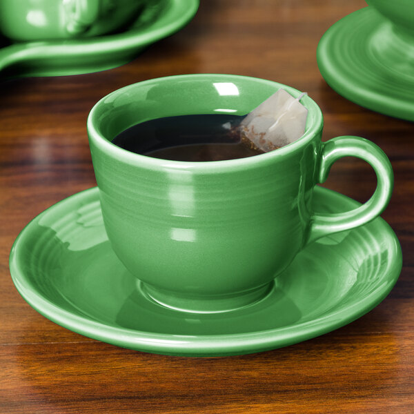 A green Fiesta saucer with a green tea cup and tea bag on it.