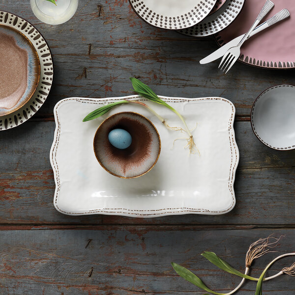 A Libbey Farmhouse ivory melamine tray on a table with plates, forks, and a blue egg.