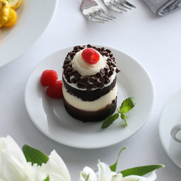 A chocolate cake with cherries and whipped cream on a 10 Strawberry Street bright white porcelain plate.