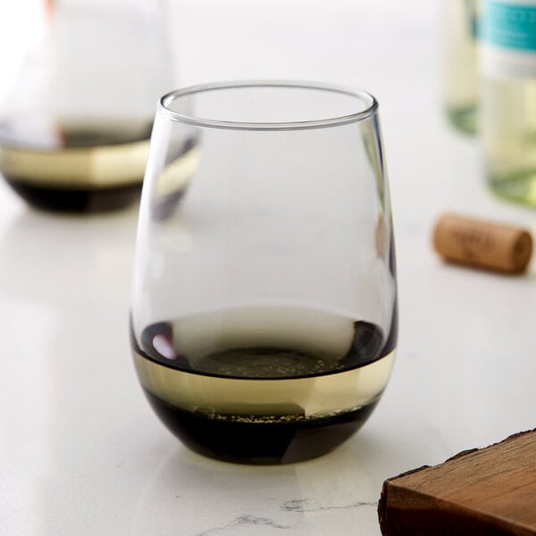 A close-up of a Libbey Moonstone Grey stemless white wine glass filled with white wine.