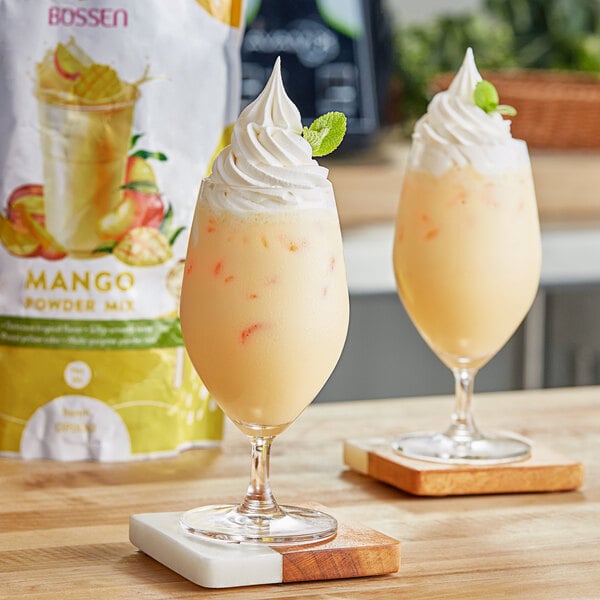 Two glasses of mango juice made with Bossen Mango Powder Mix on a table.