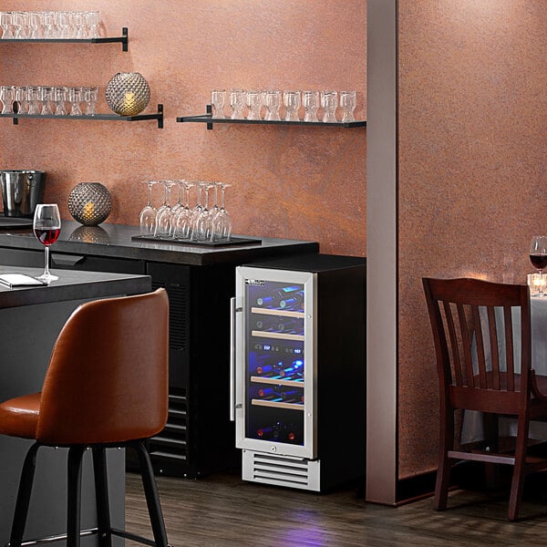 An AvaValley wine cooler with a glass door on a table with wine glasses.