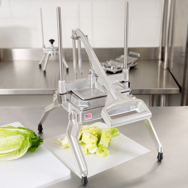 A Nemco rectangle lettuce cutter on a table with lettuce in it.