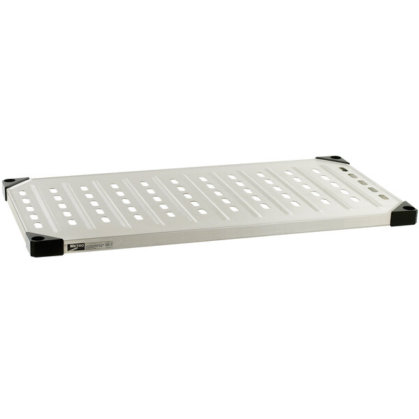 A white louvered stainless steel shelf with black dots on it.