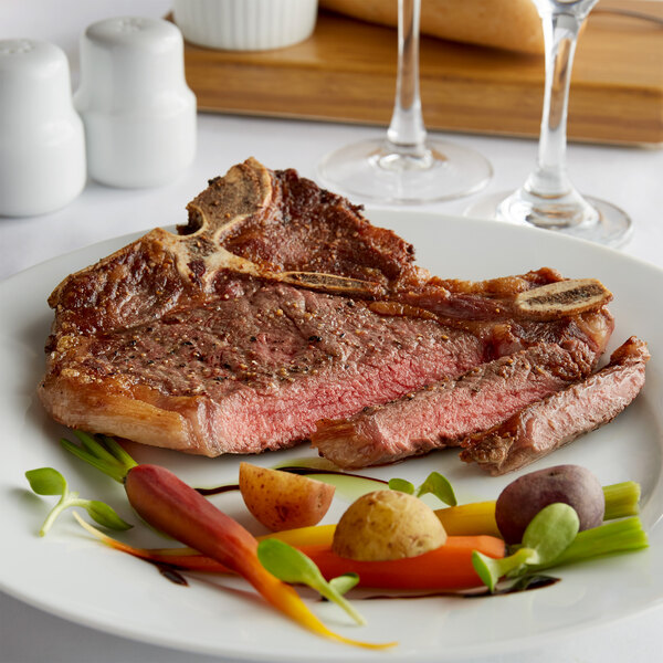 A Warrington Farm Meats T-Bone steak on a plate with vegetables.