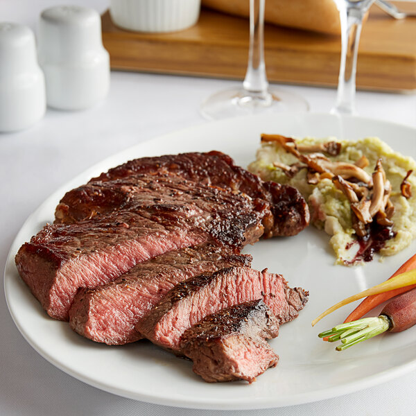 A plate with a Warrington Farm Meats Delmonico steak and vegetables.