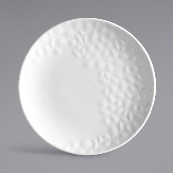 A white Reserve by Libbey Royal Rideau porcelain coupe plate with a textured pattern.