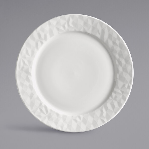 A close-up of a white Reserve by Libbey Royal Rideau porcelain plate with a diamond pattern on the rim.