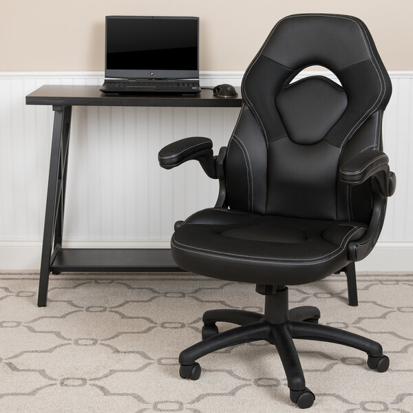 A black Flash Furniture office chair with a laptop on the arm rest.