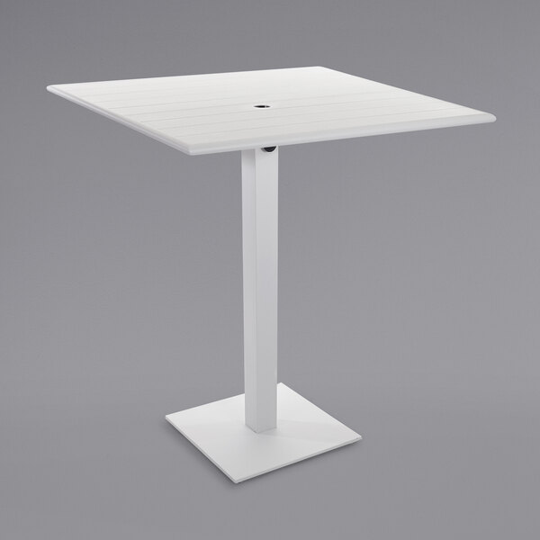 A BFM Seating white square table with a square base and umbrella hole.