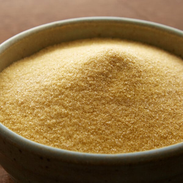 A bowl of brown Regal Adobo Seasoning without Pepper on a wooden table.