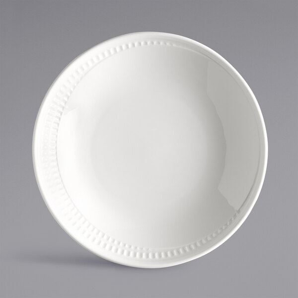 A close up of a Libbey Royal Rideau white deep coupe plate with a decorative edge.
