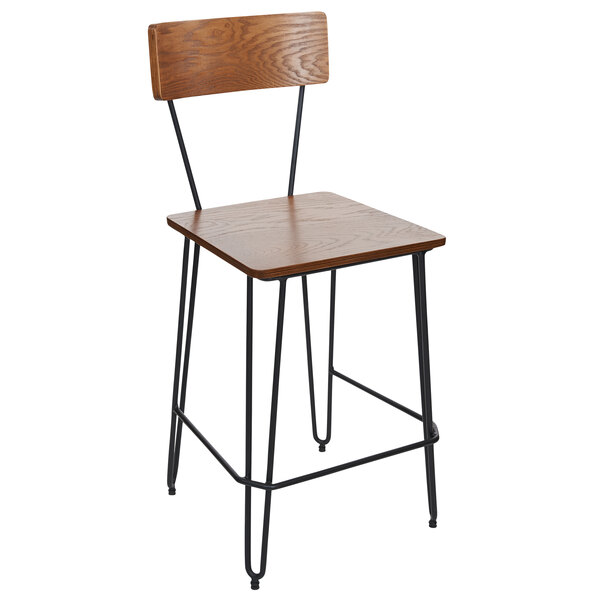 A BFM Seating black steel wire bar stool with a wooden seat.