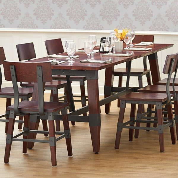 Lancaster Table & Seating mahogany wooden trestle table base on a wooden table with chairs.