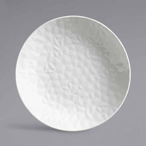 A white porcelain deep coupe plate with a textured surface.