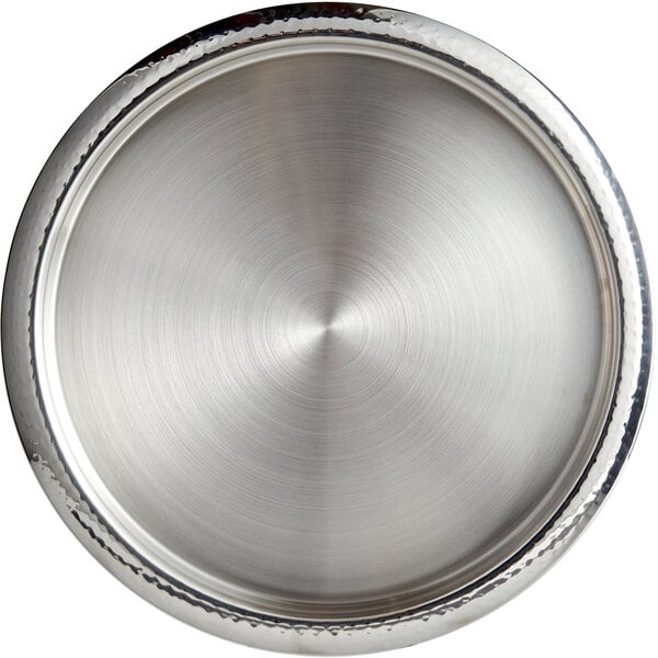 A close up of a Libbey stainless steel circular serving tray with a hammered rim.