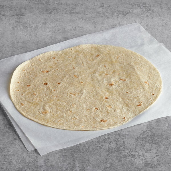 A Mission 13" flour tortilla on a white surface.