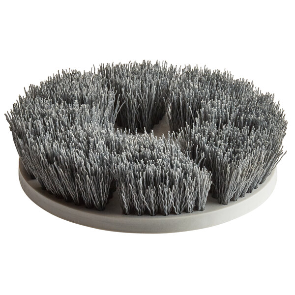 A close-up of a MotorScrubber gray tile and grout brush with many thin bristles.