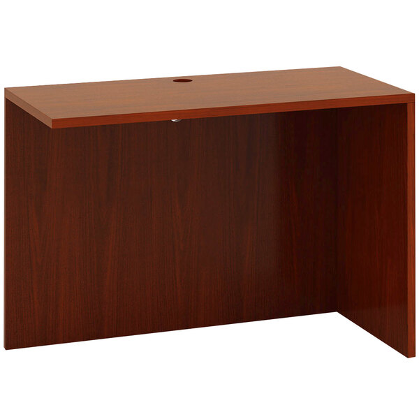 A Boss cherry wood desk with a reversible return shelf.