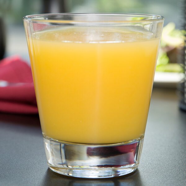 A Libbey Elan double old fashioned glass filled with orange juice on a table.