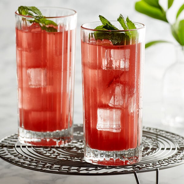 Two Libbey cooler glasses with a red drink and ice.
